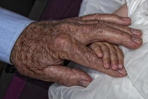 gammal pensionerad man händer innehav nyfödd spädbarn ett foto