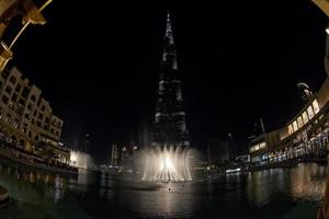 burji khalifa på natt med fontän visa i dubai foto