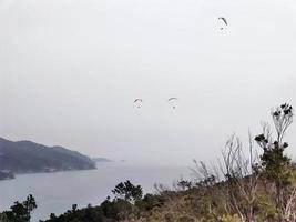 paraglider på molnig himmel i monterosso cinque terre Italien foto