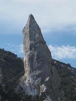 klättrare på goloritze sten klippa förbi de hav sardinien Italien foto
