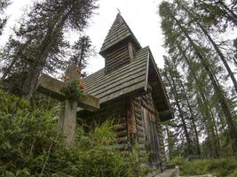 jag värld krig gammal trä kyrka och kyrkogård i dolomiter valparola foto