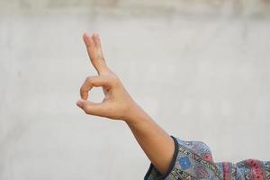 kvinna håller på med hand gester som en tecken av ok foto
