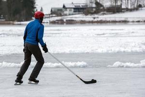 människor spelar hockey på frysta sjö foto