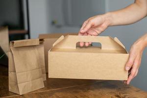 en mock-up av en disponibel mat låda i de händer av en kvinna foto