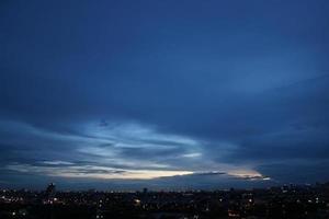 mörk blå moln med vit ljus himmel bakgrund och stad ljus midnatt kväll tid foto