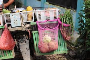 en gårdfarihandlare säljer grönsaker på hans motorcykel till byar i ett av Indonesiens regioner foto