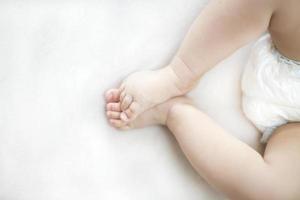 små baby flicka fötter på sängen