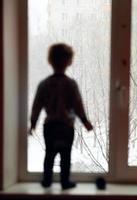silhuett av en pojke nära ett fönster foto
