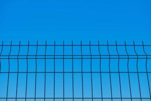 metall staket mot de bakgrund av en blå gränslös himmel, en suddig bakgrund, de aning av frihet och de avlägsnande av restriktioner, en bakgrund för en affisch eller vykort foto