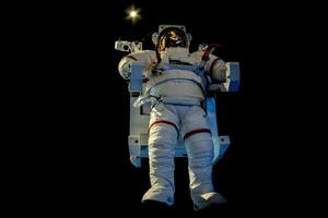 astronaut Plats kostym isolerat medan flytande på svart foto
