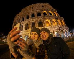 lyckliga par som tar en selfie framför colosseum foto