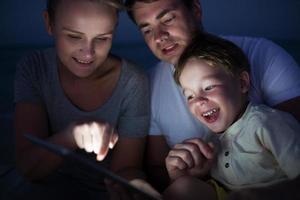 familj använder en tablett på natten foto