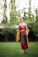 vacker kvinna som bär en typisk thailändsk klänning foto
