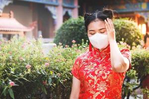 asiatisk kvinnor ha på sig röd kinesisk Kläder, ha på sig masker till förhindra bakterier. hon känt sjuk med en huvudvärk tycka om en coronavirus 2019. de begrepp av virus skydd foto