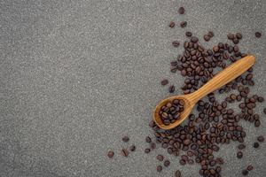 mörka rostade kaffebönor på stenbakgrund foto