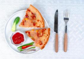 klassisk pizza med ost på de tabell i en Kafé på en trä- stå med en skära triangel- bit och en pizza kniv foto