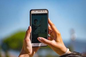selfie avlägsen kontrollera på cellulär telefon på pisa lutande torn foto