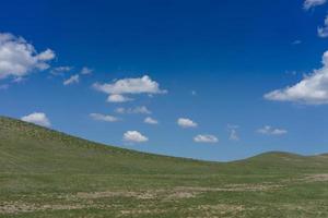 landskap med åkrar och kullar och molnig blå himmel foto