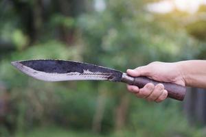 närbild hand innehar årgång kniv i de kväll ljus. begrepp , verktyg eller Utrustning i kök, använda sig av för hacka, skärande när matlagning eller Övrig syften som vapen, jakt. knivar i lokal- kök foto