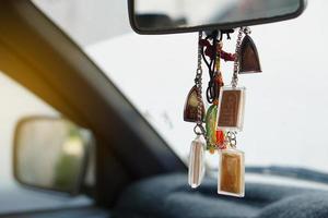 närbild buddha amuletter hänga i främre trösta av de bil. begrepp, tro och tro för buddist för helig och tur. förebyggande från olycka. foto