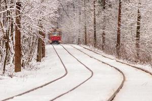 ett gammal spårvagn rör på sig genom en vinter- skog foto