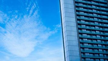 glas byggnad med balkong med blå himmel bakgrund, abstrakt del av modern arkitektur, glas och betong väggar foto