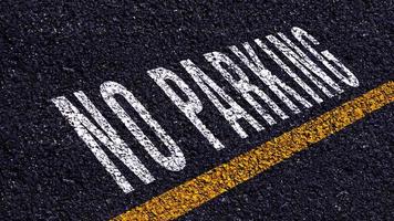 Nej parkering skriven och gul linje på de väg i mitten av de asfalt väg, Nej parkering ord på gata. foto
