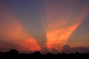 atmosfär i de kväll himmel som de Sol uppsättningar - balkar - av de Sol och moln skapa skön färger och många färger, skapande en värma och romantisk atmosfär på en sommar kväll. foto