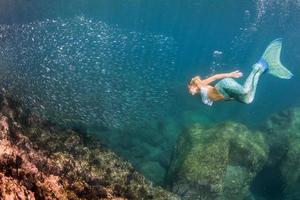 blond skön sjöjungfru dykare under vattnet foto