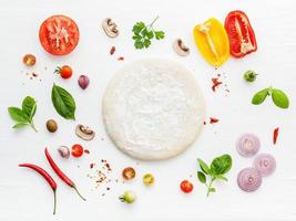 pizzadeg och ingredienser på vitt foto