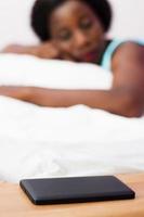 kvinna som sover med sin mobiltelefon bredvid henne