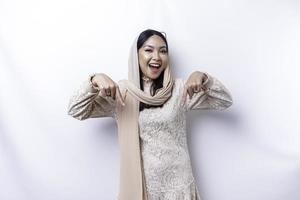 upphetsad asiatisk muslim kvinna hijab pekande på de kopia Plats Nedan henne, isolerat förbi vit bakgrund foto