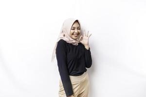 porträtt av en leende asiatisk muslim kvinna, ger ett ok hand gest isolerat över vit bakgrund foto