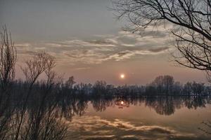 underbar sjö solnedgång i vinter- tid foto