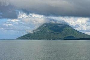 vulkan Bakom indonesiska fiskare by tropisk paradis foto