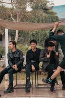 en grupp av asiatisk tonåringar i svart kläder stiliserade som stygg barn medan sammankomst på en Kafé foto