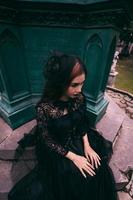 ett asiatisk kvinna klädd Allt i svart var Sammanträde i en kyrkogård med en mycket skrämmande uttryck medan delta de död av henne bror foto