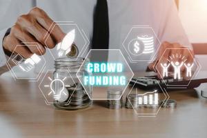 crowdfunding begrepp, företag person hand sätta pengar in i burk glas med crowdfunding ikon på virtuell skärm, samarbete, tillväxt och lämna tillbaka. foto