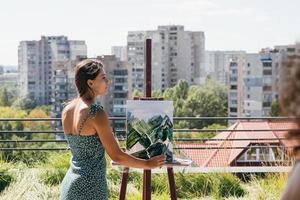 ung konstnär målarfärger mot de bakgrund av de stad foto