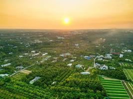 gyllene timme magi hisnande solnedgång över tien giang provins fält med lugn flod och stadsbild i vietnam foto