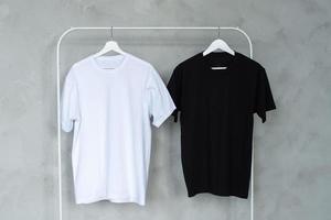svart och vit t-shirt hängande på en galge, layout foto