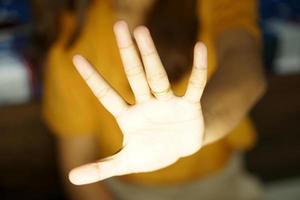 asiatisk kvinna använder sig av henne händer till blockera de lysa skarpt av en dator övervaka foto