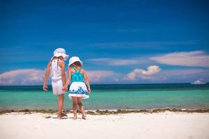 liten flickor har roligt på de strand foto