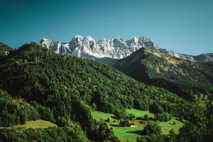 majestätisk bergen i de alps täckt med träd och moln foto