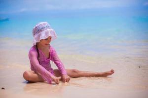 liten flicka har roligt på de strand foto