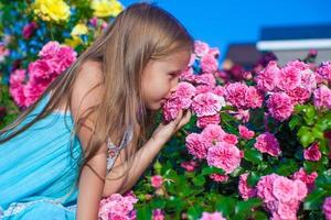 liten flicka med skön blommor foto