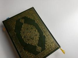 läsning al quran och vändning sida av quran ovan sajadah bön- matta isolerat på vit Plats. vald fokus foto