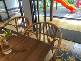interiör av restaurang med trä- tabell och trä- prydnad. tömma sittplats och tabell i restaurang. stänga upp rena tabell och stol foto
