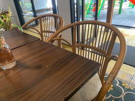 interiör av restaurang med trä- tabell och trä- prydnad. tömma sittplats och tabell i restaurang. stänga upp rena tabell och stol foto