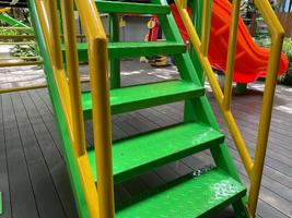 barn trappa. grön och gul stål trappa med järn hand räcke och maska. barn trappa design för lekplats och skola. foto